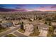 Stunning aerial view of the home nestled in a peaceful neighborhood with mature trees, sidewalks, and mountain views at 15907 W 72Nd Dr, Arvada, CO 80007