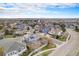 An aerial view captures a neighborhood with tree-lined streets and well-maintained homes on a sunny day at 15907 W 72Nd Dr, Arvada, CO 80007