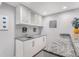 Basement bar area with white cabinets, granite countertop, and stainless steel sink at 15907 W 72Nd Dr, Arvada, CO 80007