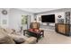 Cozy basement featuring a plush sofa, large television, and stylish decor, perfect for entertainment at 15907 W 72Nd Dr, Arvada, CO 80007