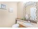 Elegant half-bathroom with a decorative mirror, granite countertop, and stylish fixtures at 15907 W 72Nd Dr, Arvada, CO 80007