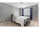 Serene bedroom with a gray accent wall, soft carpeting, and a large window with light-filtering shades at 15907 W 72Nd Dr, Arvada, CO 80007