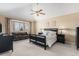 Spacious bedroom with a bay window, ceiling fan, a cozy sitting area with a couch and neutral colored walls at 15907 W 72Nd Dr, Arvada, CO 80007