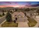 Charming two-story home featuring a well-maintained lawn, three-car garage and mountain views at sunset at 15907 W 72Nd Dr, Arvada, CO 80007