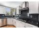 A close up of the kitchen highlighting stainless steel appliances, granite countertops, and white cabinets at 15907 W 72Nd Dr, Arvada, CO 80007