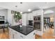 Modern kitchen boasts stainless steel appliances, dark granite countertops, and a center island with white cabinets at 15907 W 72Nd Dr, Arvada, CO 80007