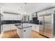 Bright kitchen features white cabinets, stainless steel appliances, an island with granite countertop, and natural light at 15907 W 72Nd Dr, Arvada, CO 80007