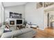 Cozy living room with a fireplace, a gray sectional sofa, and natural light at 15907 W 72Nd Dr, Arvada, CO 80007