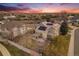 This aerial view features a backyard with a covered patio, mature trees, and solar panels on the roof at 15907 W 72Nd Dr, Arvada, CO 80007