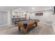 A home recreation room features a pool table, a bar with seating, and recessed ceiling lights at 15907 W 72Nd Dr, Arvada, CO 80007