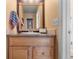 Half bathroom with wooden vanity and countertop, decorative mirror, and neutral wall color at 17467 E Rice Cir # C, Aurora, CO 80015