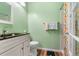 Fresh bathroom with a green wall, toilet, vanity, and shower with floral curtain at 17467 E Rice Cir # C, Aurora, CO 80015