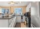 Bright kitchen with white cabinets, granite countertops, stainless steel appliances, and large window at 17467 E Rice Cir # C, Aurora, CO 80015