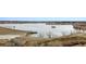 Scenic view of a calm lake with concrete structures and dry vegetation, highlighting the natural surroundings at 17467 E Rice Cir # C, Aurora, CO 80015