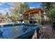Serene backyard featuring a luxurious hot tub, covered deck with seating, mature trees, and a peaceful outdoor space at 4645 Quitman St, Denver, CO 80212