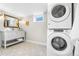 Charming bathroom with stacked washer/dryer unit, modern vanity, and designer floor tiles at 4645 Quitman St, Denver, CO 80212