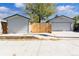 View of the garages behind a wooden gate, offering secure parking and storage at 4645 Quitman St, Denver, CO 80212
