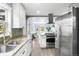 Bright kitchen with stainless steel appliances, stylish backsplash, and an open view to the living room at 4645 Quitman St, Denver, CO 80212