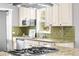 Well-lit kitchen with stainless appliances, granite counters, green backsplash, and ample cabinet space at 4645 Quitman St, Denver, CO 80212