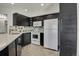 This kitchen features dark wood cabinets and white appliances, complemented by stylish countertops and flooring at 5250 S Huron Way # 3-205, Littleton, CO 80120