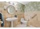 Elegant bathroom featuring tiled walls, decorative wallpaper, and a pedestal sink with designer fixtures at 1025 S Butler Way, Lakewood, CO 80226