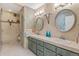 Charming bathroom with dual sinks, large mirrors, tiled walls, and a walk-in shower at 1025 S Butler Way, Lakewood, CO 80226