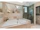 Spa-like bathroom featuring a soaking tub and a glass-enclosed shower with multiple shower heads at 1025 S Butler Way, Lakewood, CO 80226