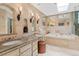 Luxurious bathroom with dual sinks, granite countertops, and a soaking tub with a decorative stool at 1025 S Butler Way, Lakewood, CO 80226