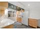 Basement kitchenette featuring white appliances, wood cabinets, and tile floor at 1025 S Butler Way, Lakewood, CO 80226