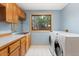 Functional laundry room with cabinetry, countertop space, sink, window, and modern washer and dryer at 1025 S Butler Way, Lakewood, CO 80226