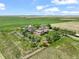 Picturesque property with lush green fields, mature trees, and a charming two-story home at 1335 S Kio St, Watkins, CO 80137