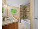 Bathroom with double sink vanity, large window, tiled shower over tub, and updated fixtures at 1335 S Kio St, Watkins, CO 80137