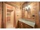 Charming bathroom with a wood paneled vanity, a stylish mirror, and a shower behind a door at 1335 S Kio St, Watkins, CO 80137