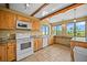 Bright kitchen features wood cabinets, neutral tile floors, and a large window offering views of the surrounding landscape at 1335 S Kio St, Watkins, CO 80137