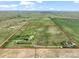 Aerial view of large property with perimeter highlighted in red, featuring pastures, trees, and several houses at 1335 S Kio St, Watkins, CO 80137