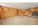 Open-concept living room features a stone fireplace, built-in shelving, wood paneling, and staircase at 1335 S Kio St, Watkins, CO 80137