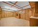 Large rec room with built-in shelving, wood paneling, drop ceiling and tile flooring at 1335 S Kio St, Watkins, CO 80137