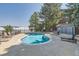 Kidney-shaped community pool and seating area surrounded by mature trees at 7893 Allison Way # 101, Arvada, CO 80005