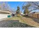 Spacious backyard with a lush lawn, mature trees, and detached garage perfect for outdoor activities at 2230 Jamaica St, Aurora, CO 80010
