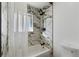 Modern bathroom with a marble tiled shower, black fixtures, and a window for natural light at 2230 Jamaica St, Aurora, CO 80010