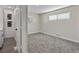 Neutral bedroom boasts carpeted floors, base trim, and a window for ample natural light at 2230 Jamaica St, Aurora, CO 80010