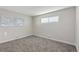 Cozy bedroom featuring neutral walls, carpet, and two windows for abundant natural light at 2230 Jamaica St, Aurora, CO 80010