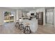 Bright, modern kitchen features stainless steel appliances, an island with seating, and sliding doors to the backyard at 2230 Jamaica St, Aurora, CO 80010