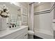 Clean bathroom featuring a bathtub, shower, a stylish vanity with black hardware at 8360 Snake River St, Littleton, CO 80125