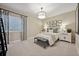 Cozy bedroom featuring a window, modern light fixture, and bench seating at the foot of the bed at 8360 Snake River St, Littleton, CO 80125