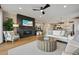 Bright living room featuring a fireplace, modern ceiling fan, and wood flooring at 8360 Snake River St, Littleton, CO 80125