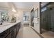Main bathroom featuring dual sinks, granite countertops, and a walk-in shower at 8360 Snake River St, Littleton, CO 80125