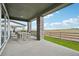Inviting covered patio with stone pillars, outdoor seating, and an expansive view at 8360 Snake River St, Littleton, CO 80125