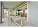 Covered patio with outdoor dining table, chairs and views of the interior living spaces through glass sliding doors at 8360 Snake River St, Littleton, CO 80125
