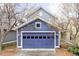View of a blue garage with a carriage door and a concrete driveway at 9124 E 29Th Pl, Denver, CO 80238